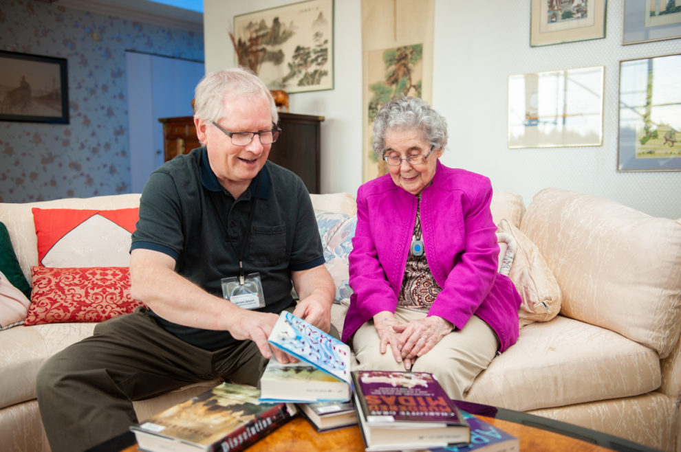 Home Library and Accessible Service staff discussing book selection with a patron in their home