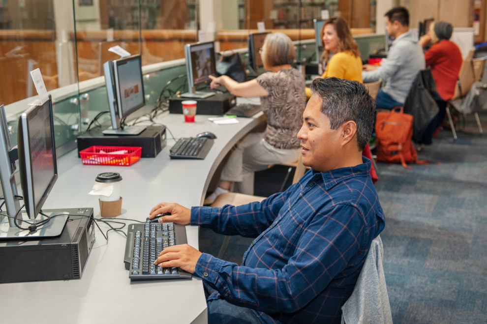 People sitting at computer stations at the Bob Prittie Metrotown Branch