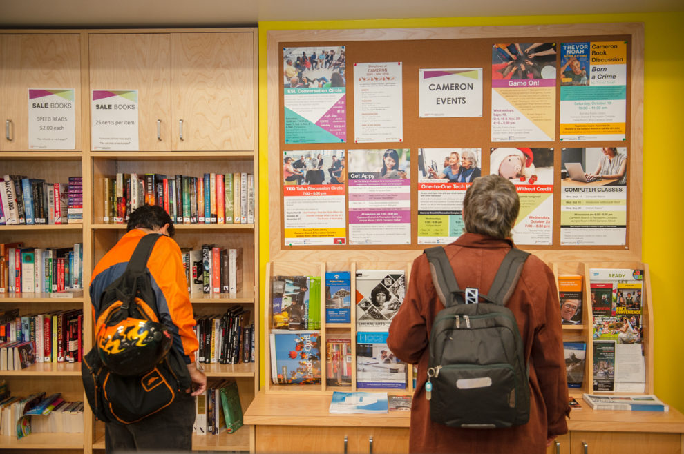 Person looking at the Library program bulletin board at Cameron Branch