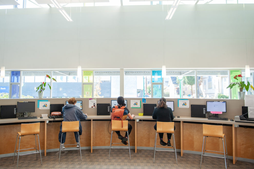 People sitting at public computer stations at Tommy Douglas Library