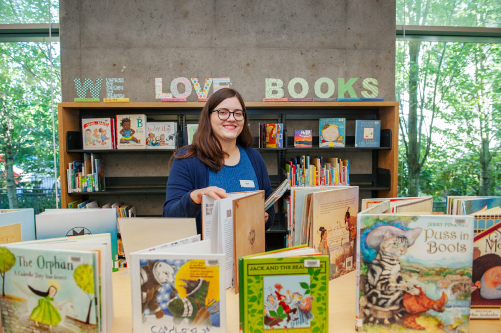 Children's librarian at Tommy Douglas Library surrounded by picture books